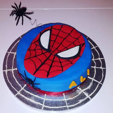 Gâteau rond bleu avec le masque rouge de Spider-Man et une araignée