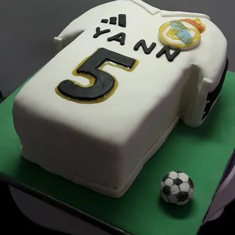 Gâteau en forme de maillot de football blanc portant le numéro 5, avec un ballon
