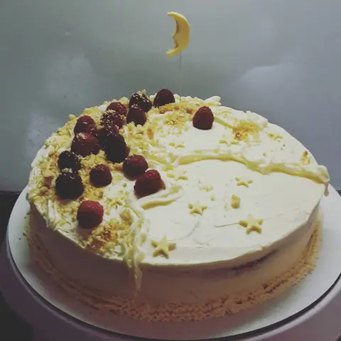 Gâteau à la crème décoré de fruits rouges, d'étoiles et d'un croissant de lune