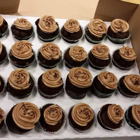 Cupcakes au chocolat surmontés de crème au café, rangés dans une boîte
