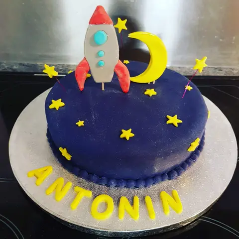 Gâteau bleu nuit étoilé avec une fusée et un croissant de lune