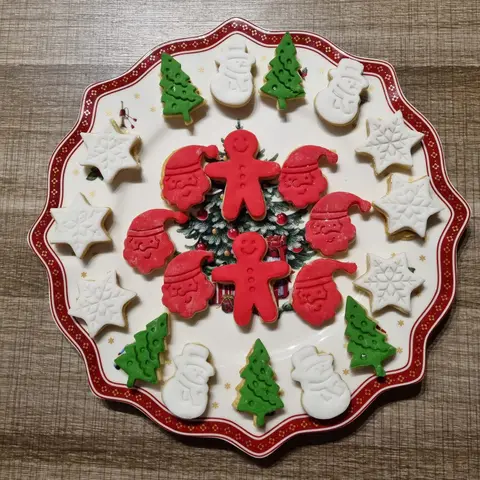 Assiette de sablés de Noël : sapins verts, bonshommes de pain d'épices rouges et flocons blancs