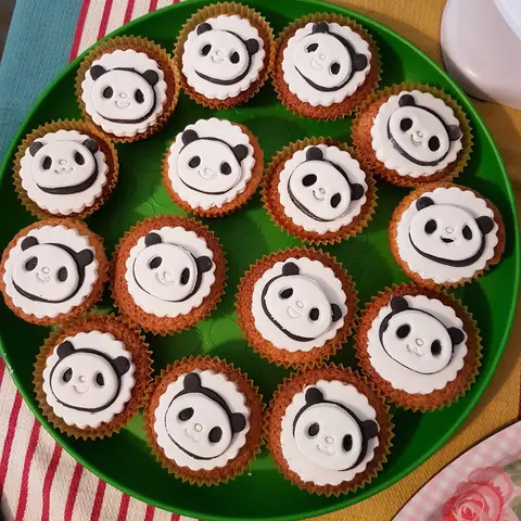Cupcakes décorés de têtes de panda, disposés sur un plat vert