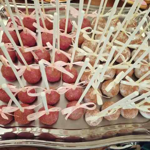 Cake pops roses piqués sur des bâtonnets noués d'un ruban