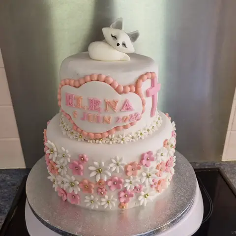 Gâteau blanc à deux étages couvert de petites fleurs roses, un renard blanc endormi au sommet