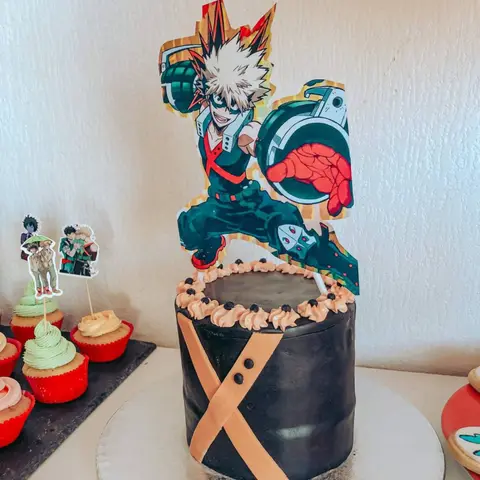 Gâteau noir surmonté d'une silhouette imprimée de Bakugo, de My Hero Academia, cupcakes assortis