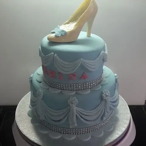 Gâteau bleu gris à deux étages drapé, surmonté d'un escarpin en sucre