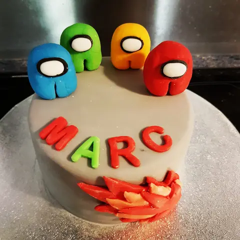 Gâteau gris surmonté de quatre personnages d'Among Us