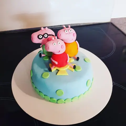 Gâteau bleu surmonté d'une Peppa Pig et sa famille