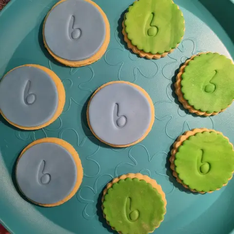 Sablés ronds recouverts de pâte à sucre bleue ou verte, chacun marqué en relief d'un chiffre 6