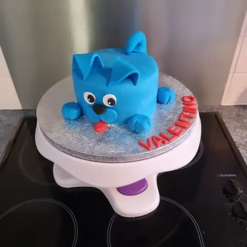 Petit gâteau en forme de chien bleu aux oreilles tombantes, tirant une langue rouge, avec un prénom rouge