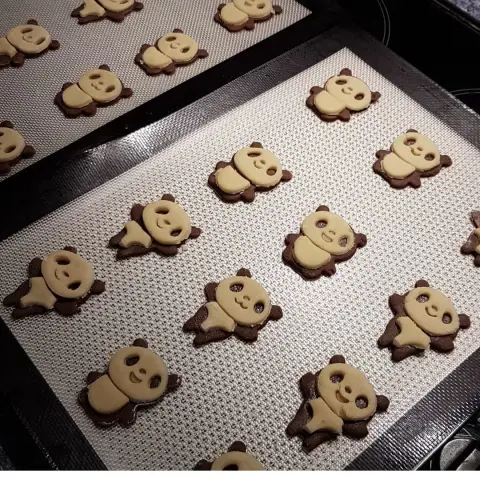 Plaques de sablés bicolores en forme de pandas souriants, pâte vanille et chocolat, prêts à cuire