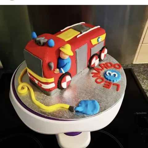 Camion de pompiers rouge en pâte à sucre avec son pompier, un tuyau jaune, un prénom et le chiffre 3