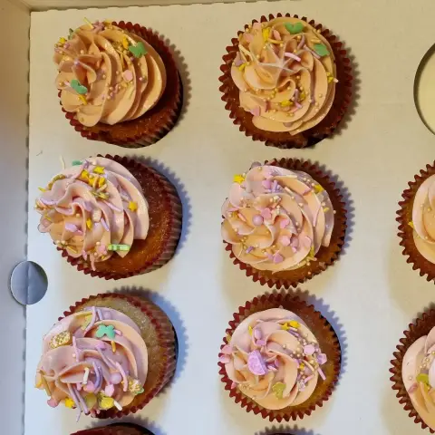 Cupcakes à la crème rose pêche en rosace, parsemés de vermicelles, de cœurs et de perles pastel